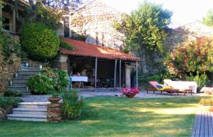uma casa com um jardim com uma mesa e cadeiras em Casa da Pedra - Turismo Rural em Bragado