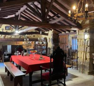 a dining room with a table with a red table cloth at Casa da Pedra - Turismo Rural in Bragado