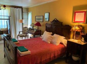 a bedroom with a large bed with a red bedspread at Casa da Pedra - Turismo Rural in Bragado +19 photos