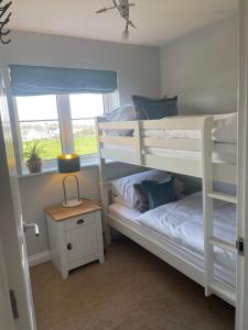 two bunk beds in a room with a window at Number 1 Longstone Court in Haverfordwest