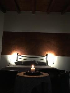 um quarto com uma cama com uma vela sobre uma mesa em B&B A Casa di Silvia em Rocca Massima