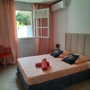 Un dormitorio con una cama con una toalla roja. en Villa Lunéa en Sainte-Luce