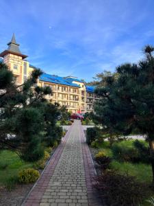 a pathway in front of a resort with trees at Apartament Blue Mare Pod Wiewiórką in Łukęcin