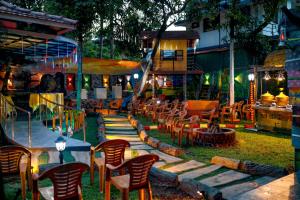 un groupe de chaises et de tables dans une cour dans l'établissement Belljem Homes -your own private resort -1 BR, à Thrissur