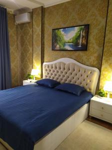 um quarto com uma cama grande e um cobertor azul em Apartment near Tashkent metro station and convenient location em Tashkent
