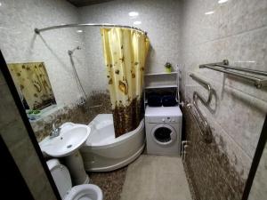 uma casa de banho com um lavatório e uma máquina de lavar roupa em Apartment near Tashkent metro station and convenient location em Tashkent