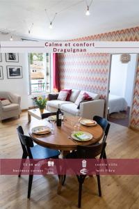 een woonkamer met een tafel en een bank bij Calme et confort en coeur de ville in Draguignan