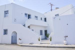 a white building with a spiral staircase on it at Niki Rooms in Adamantas