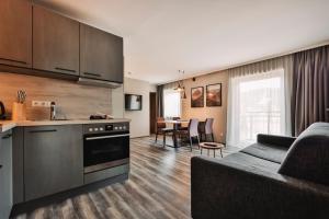a kitchen and living room with a couch and a table at LakeSide Apartments Seefeld in Seefeld in Tirol