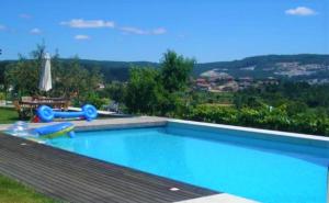 uma grande piscina azul com vista em Casa da Pedra - Turismo Rural em Bragado