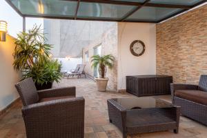 patio z krzesłami, stołem i zegarem w obiekcie Suites 259 Condesa w mieście Meksyk