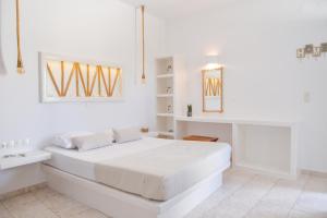 una camera bianca con un grande letto bianco di Niki Rooms ad Adámas