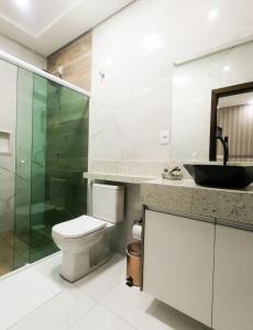 a bathroom with a toilet and a sink and a shower at Lukinhas Pousada in Nobres