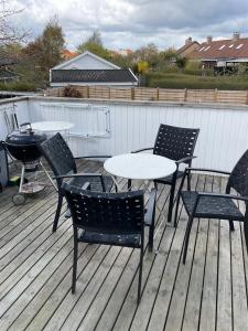 einen Tisch, Stühle und einen Grill auf einer Terrasse in der Unterkunft Stor lys lejlighed med terrasse og altan in Helsingør