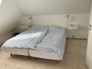Bett mit blauer und weißer Decke in einem Zimmer in der Unterkunft Stor lys lejlighed med terrasse og altan in Helsingør