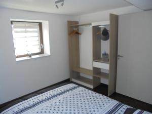1 dormitorio con cama, ventana y baño en Appartement F2 de 50m2 équipé à 5min de Colmar, en Horbourg