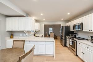 cocina con armarios blancos y suelo de madera en Waterfront Lake House en East Hampton