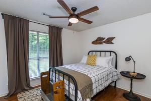 Un dormitorio con una cama y un ventilador de techo. en Abigail's Lake Haven, en Jacksons Gap