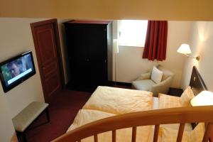 a hotel room with a bed and a television at Chez Jean in Saverne