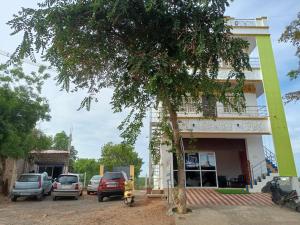 un bâtiment avec des voitures garées devant lui dans l'établissement Guru Residency Pondicherry, à Pondichéry