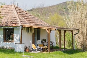 mały biały dom z krzesłami i dachem w obiekcie Rusztika Country Home w mieście Lesencetomaj