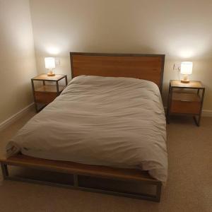 um quarto com uma cama grande e 2 mesas de cabeceira em ChurstonBnB, private flat within family home, Bolton em Lostock