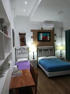 1 dormitorio con 2 camas y mesa. en HOTEL Boutique Casablanca Adrogué en Adrogué