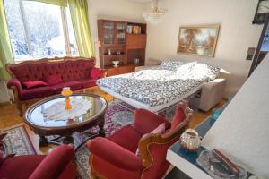 a living room with a bed and a table and chairs at A cozy house close to nature in Espoo