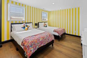 大西洋城Stylishly Renovated 5-Bedroom Home in AC - Perfect for Groups and Families的黄色条纹间内的两张床