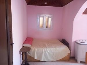 um pequeno quarto com uma cama e uma janela em Merit Roof Apartment em Hurghada