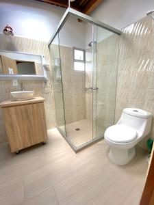 a bathroom with a shower and a toilet and a sink at HOTEL MI CASA DEL NORTE in Santa Rosa de Osos