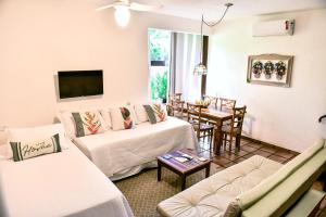 a living room with two white couches and a table at Villa Samoa - Ilhabela in Ilhabela