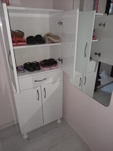 a closet with white cabinets and shoes in it at Sky IZMIR Center Big Suit Home in İzmir