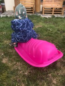 a child sitting on top of a pink board at Casa Bogát Ház in Harghita-Băi