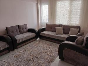 a living room with two couches and a couch and a rug at Sky IZMIR Center Big Suit Home in İzmir