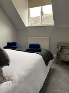 a bedroom with a bed with two blue towels on it at Stunning Apartment In The Heart of Broadway in Broadway