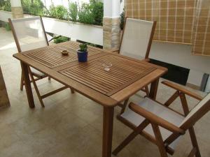een houten tafel met twee stoelen en een plant erop bij Splendid Luxury Apartments in Budva