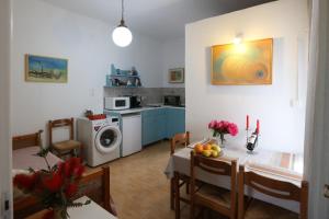 a kitchen and dining room with a table and a kitchen with a washing machine at Bella Vista in Batsi