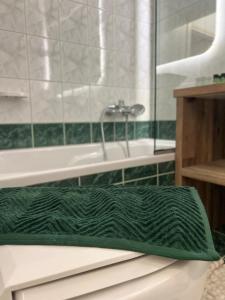 a green bath mat sitting on a bath tub at KND Living Concept - Apartment in Heraklio Town