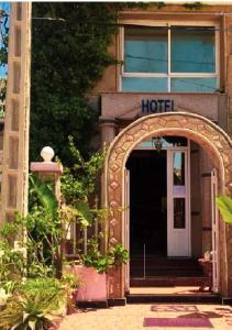 una entrada a un motel con un arco frente a un edificio en Hôtel ALMUNECAR, en Alhucemas