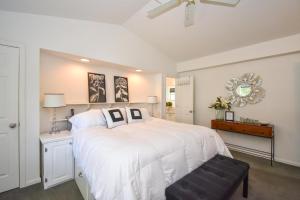 Un dormitorio con una gran cama blanca y una silla. en Eagle's Nest on Lake Martin, en Dadeville