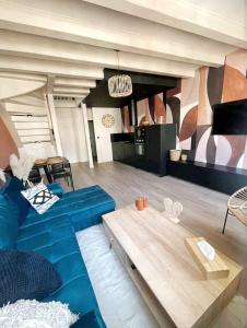 a living room with a blue couch and a table at Tres bel appartement le Concordance in Mulhouse