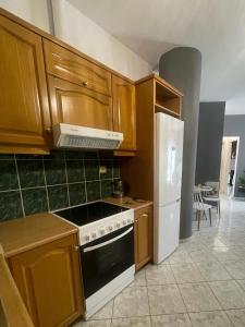 a kitchen with wooden cabinets and a stove and refrigerator at KND Living Concept - Apartment in Heraklio