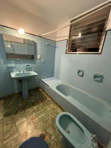 a bathroom with a tub and a sink and a toilet at Casa Alvarado Hostel in Salta