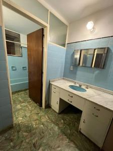 y baño con lavabo y espejo. en Casa Alvarado Hostel en Salta