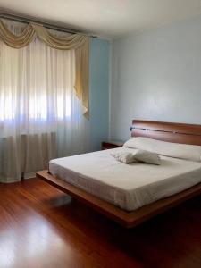 een slaapkamer met een bed en een raam met gordijnen bij Chilli House in Sottomarina