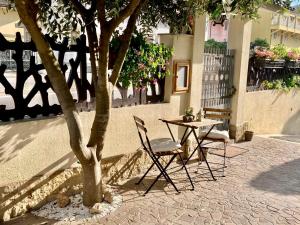 een tafel en twee stoelen naast een boom bij Chilli House in Sottomarina