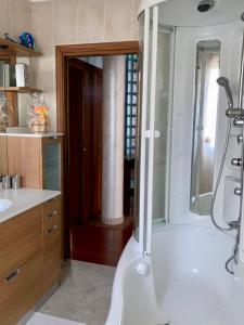 een badkamer met een douche en een wit bad bij Chilli House in Sottomarina