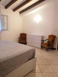 sypialnia z łóżkiem i 2 krzesłami w obiekcie Bilocale a 15 min da Alassio e Albenga w mieście Ranzo-Borgo