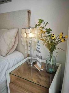 a coffee table with a vase of flowers on it at Bahia Homes Torrevieja in Torrevieja